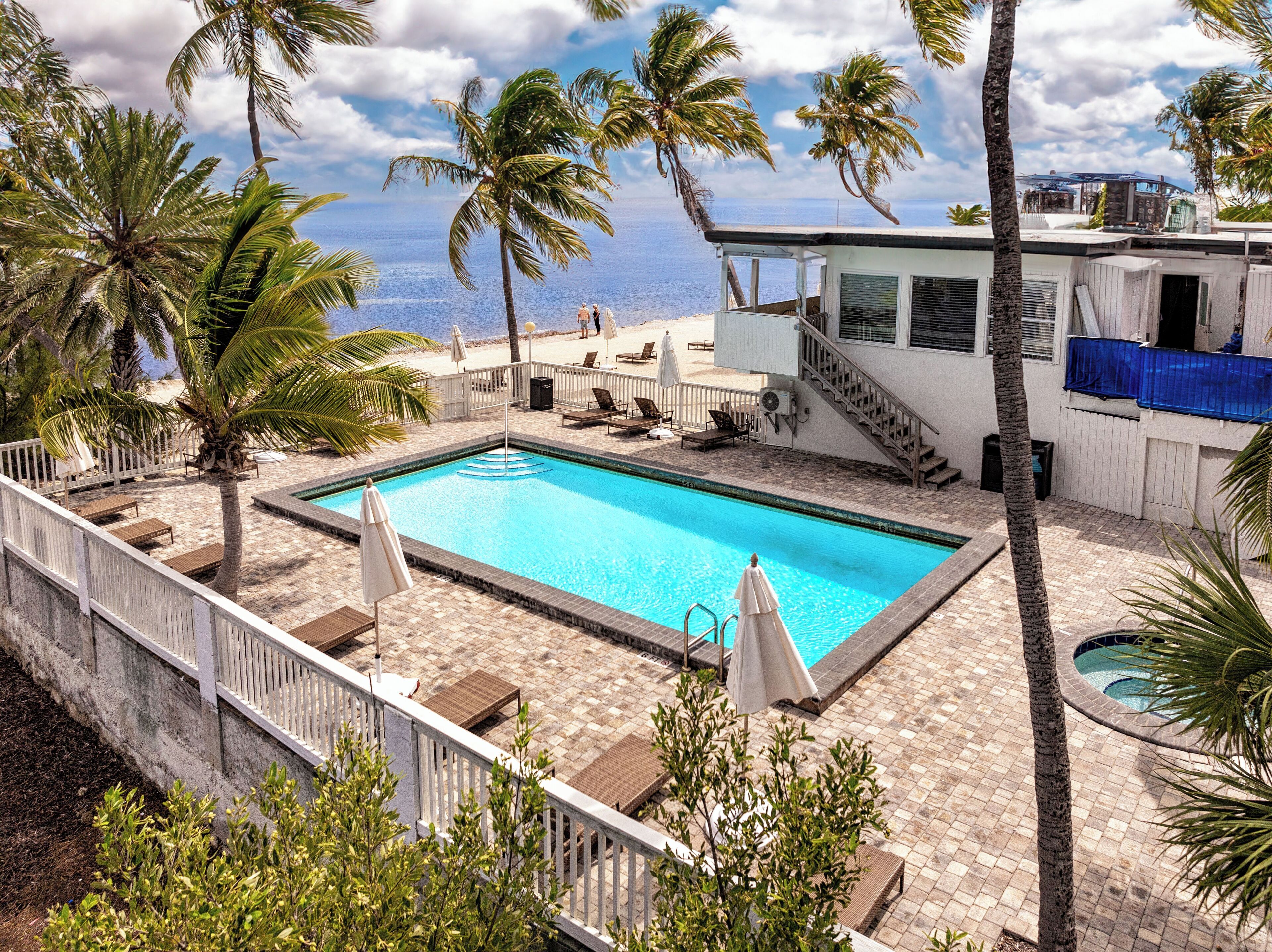 Een buitenzwembad, ligstoelen bij het zwembad