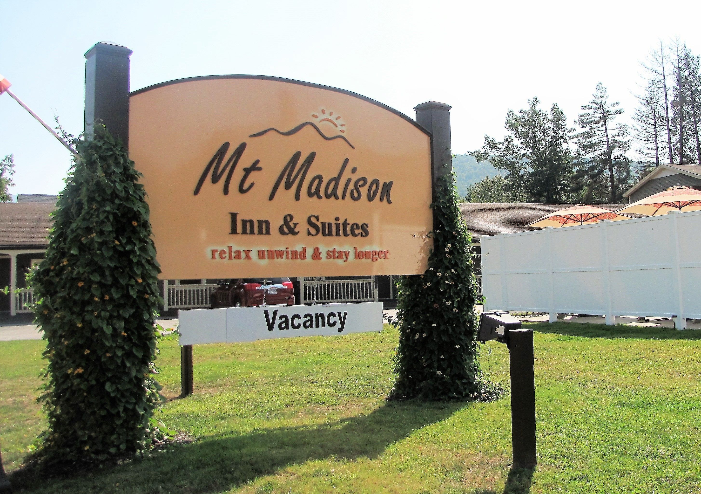 A sign for Mt. Madison Inn & Suites advertising a relaxing environment with a vacancy notice.
