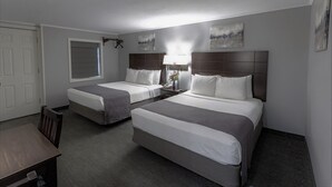 A hotel room with two beds, a desk, and a window. - Mt Madison Inn & Suites (Gorham)