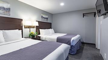 Ein Hotelzimmer mit zwei Betten, einem Nachttisch mit Lampe und einem Gemälde an der Wand.