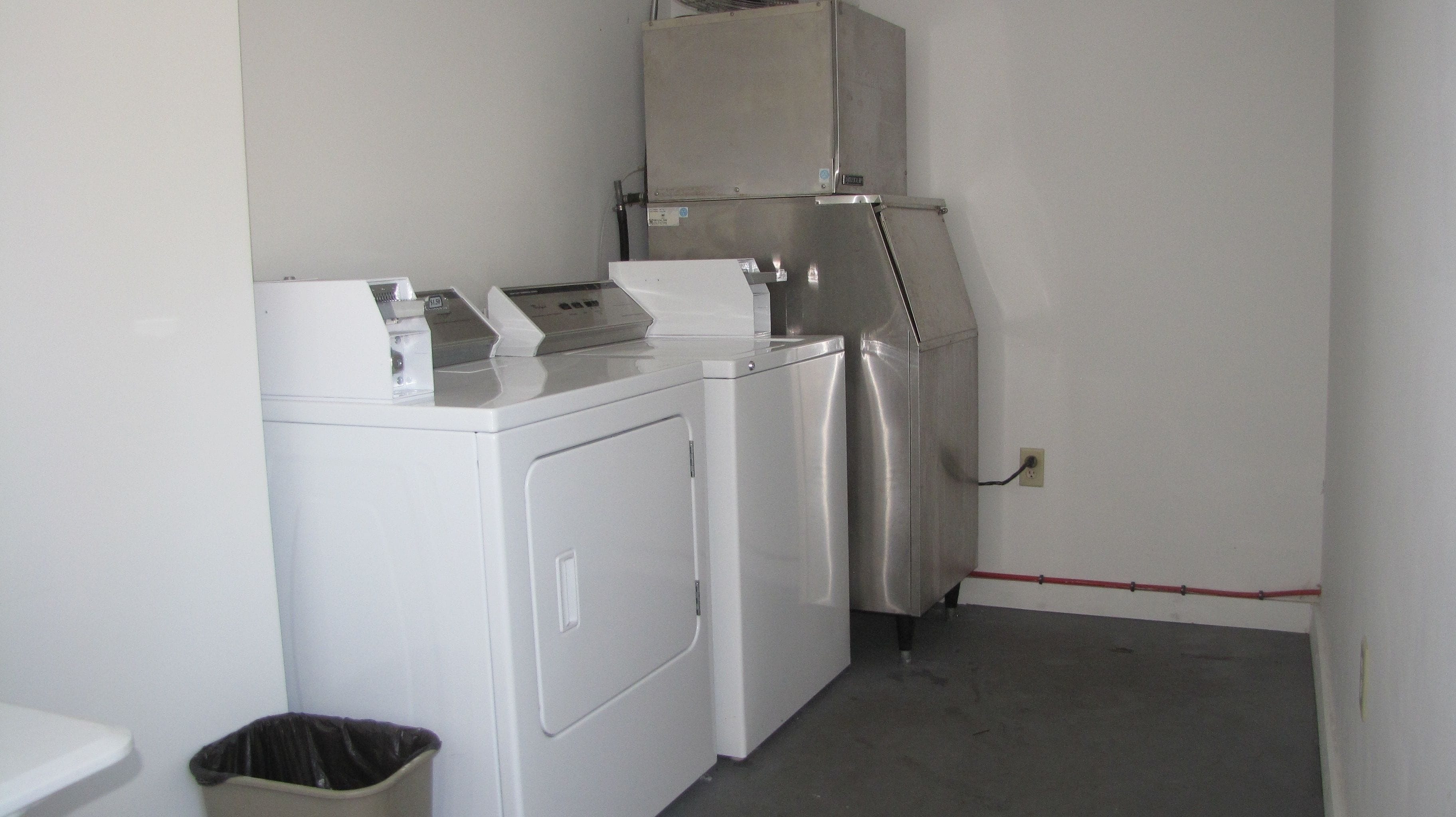 Un espace buanderie comprenant un lave-linge, un sèche-linge et des armoires superposées.