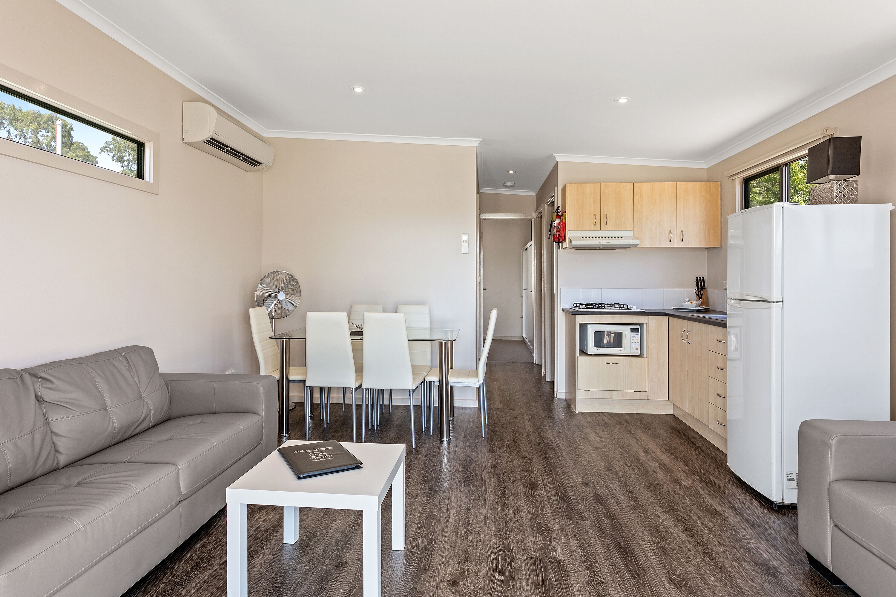 A modern apartment with a living room, dining area, and kitchen.