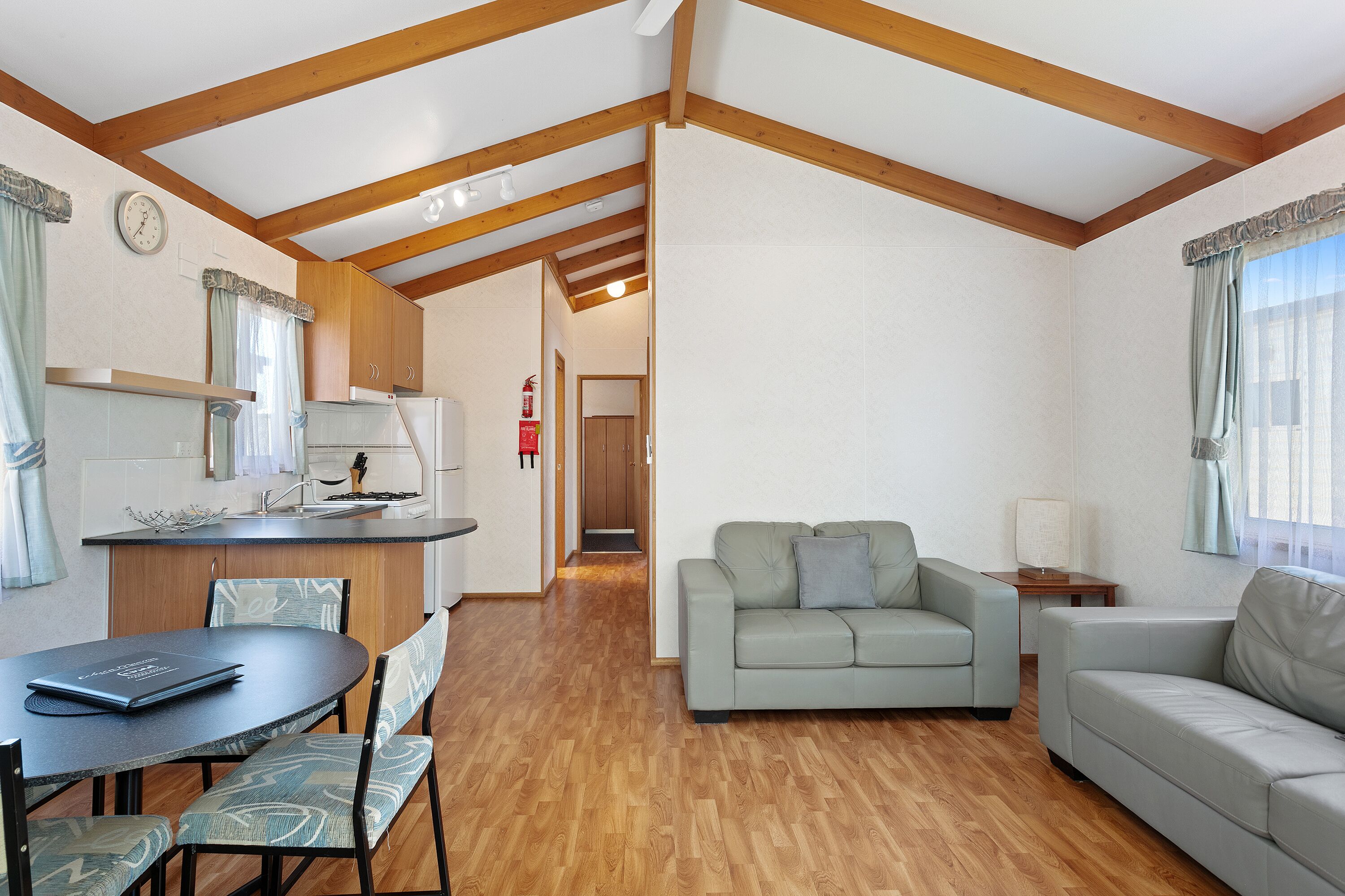 A compact living space with a kitchenette, a dining area, and a seating area with two sofas.