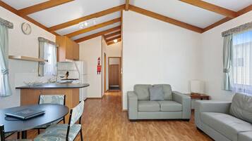 A compact living space with a kitchenette, a dining area, and a seating area with two sofas.