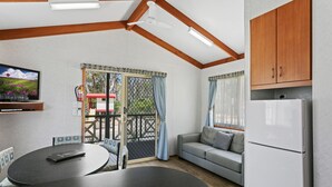 A compact kitchen with a dining area, a sofa, and a TV mounted on the wall. - BIG4 Moama Holiday Park (Moama)