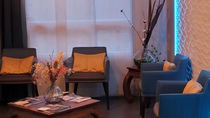 Un salon moderne avec deux canapés, une table basse et des plantes décoratives.