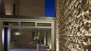 A modern building with a glass facade and a textured wall. - Balarte Hotel (Modica)