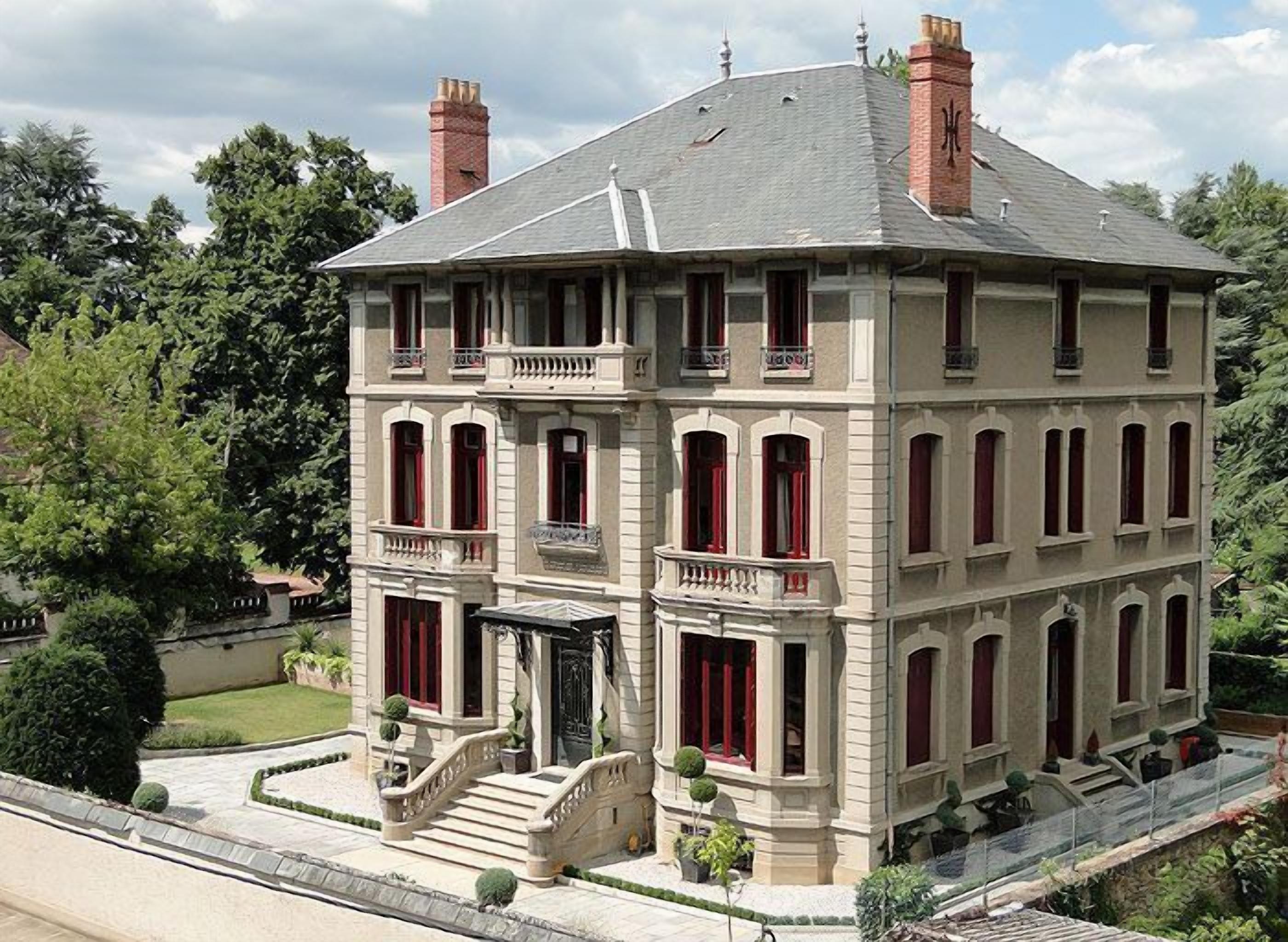 A multi-story building with a symmetrical facade, large windows, and a central entrance with steps.