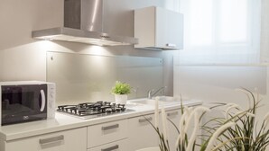 Une cuisine moderne équipée d’un four à micro-ondes, d’une cuisinière, d’un évier et de placards.