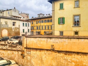 Una serie di edifici storici con diversi stili architettonici, tra cui un edificio giallo con persiane verdi.