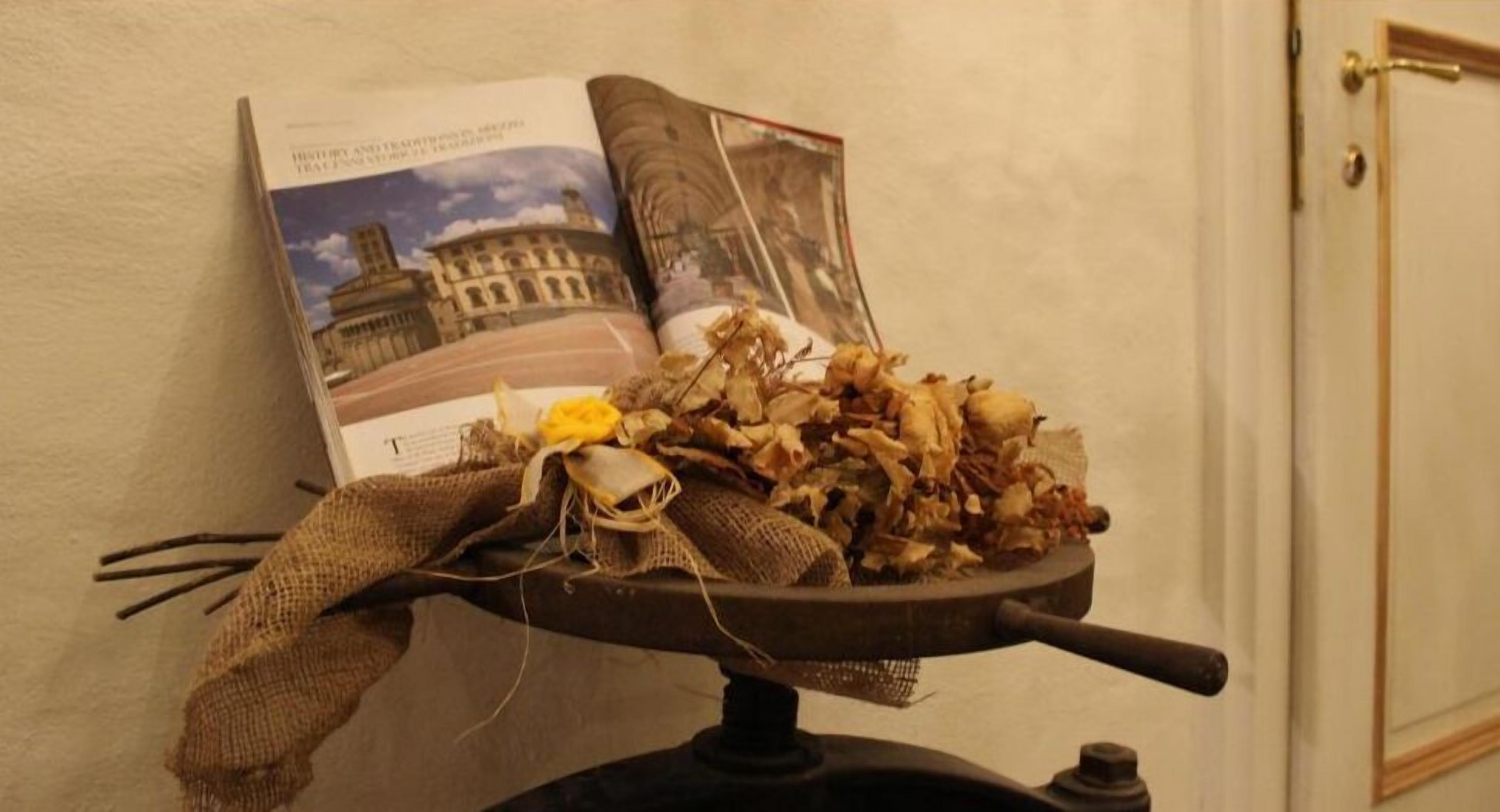 Een boek met op de omslag een historisch gebouw, geplaatst op een tafel met een rustieke decoratie.