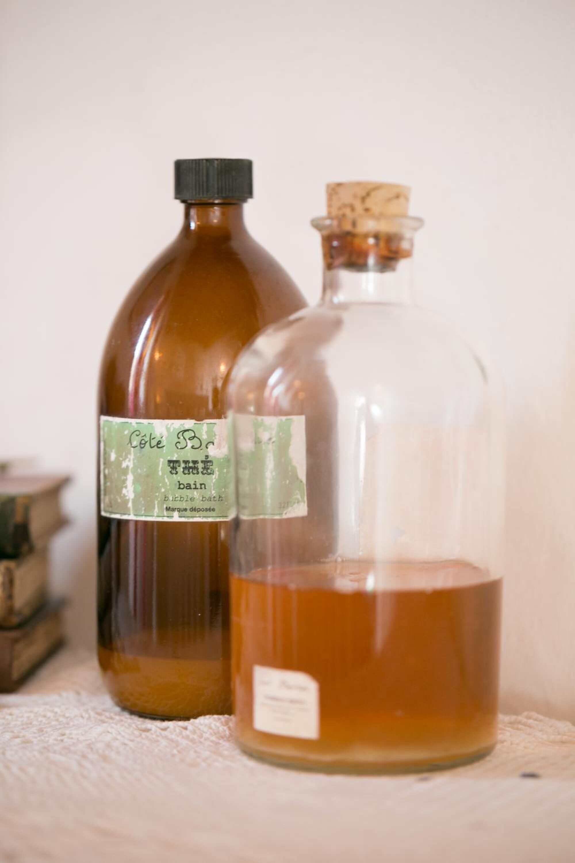 Two bottles with labels, one brown and one clear, on a white surface.