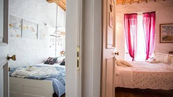 Un dormitorio con una cama, una mesita de noche y una ventana con cortinas.