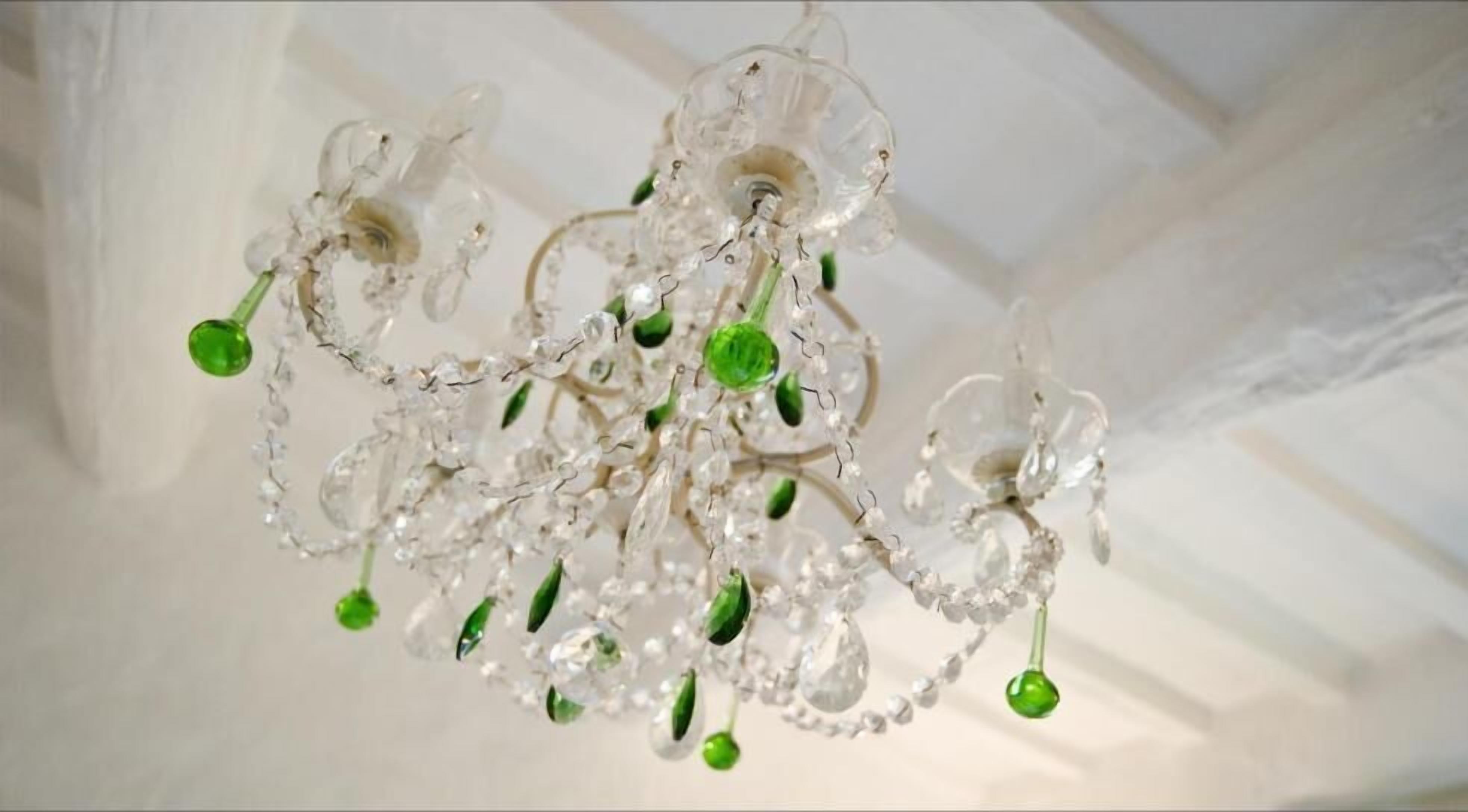 A chandelier with clear glass elements and green accents.