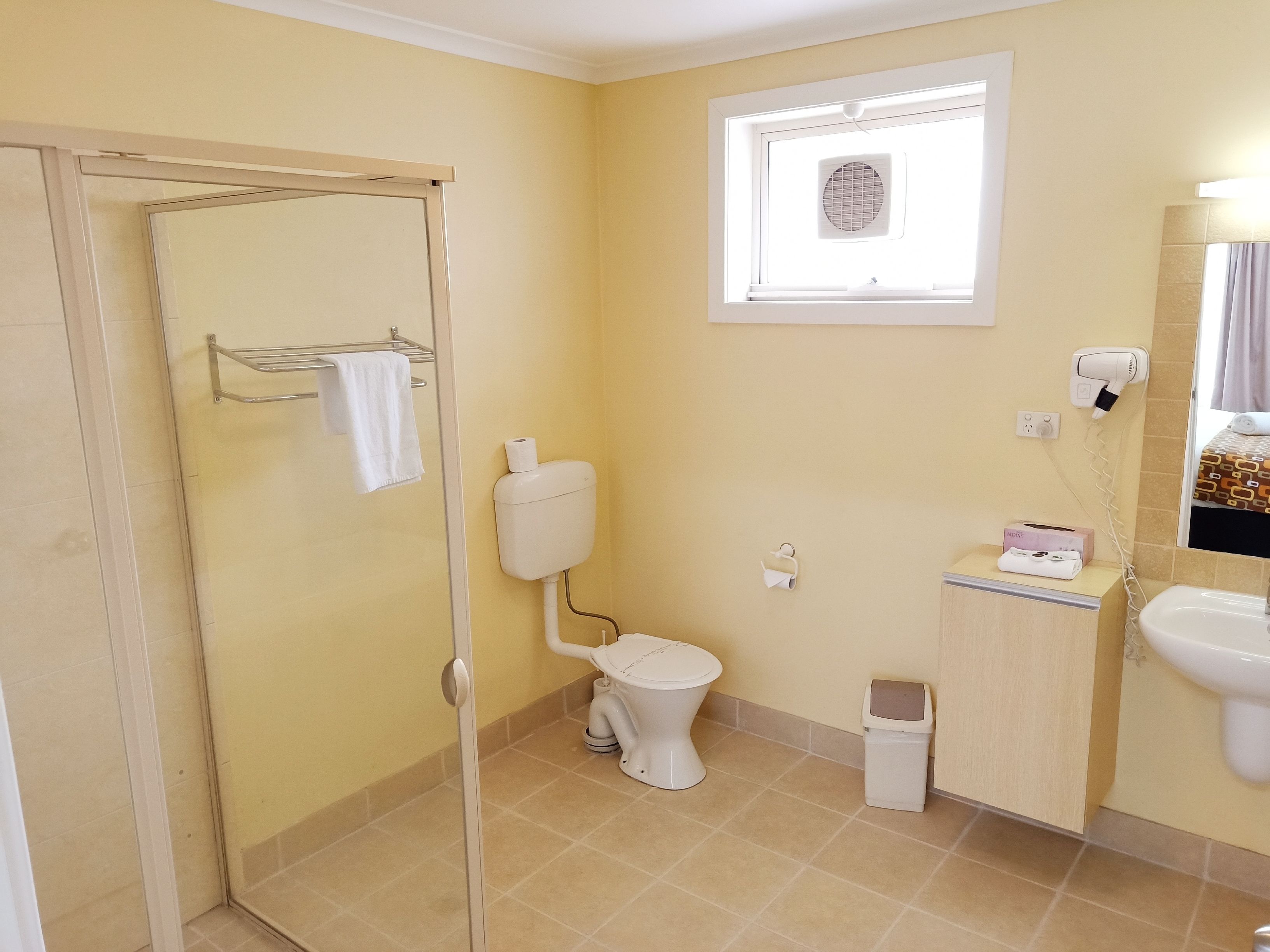 A bathroom with a toilet, sink, and shower.
