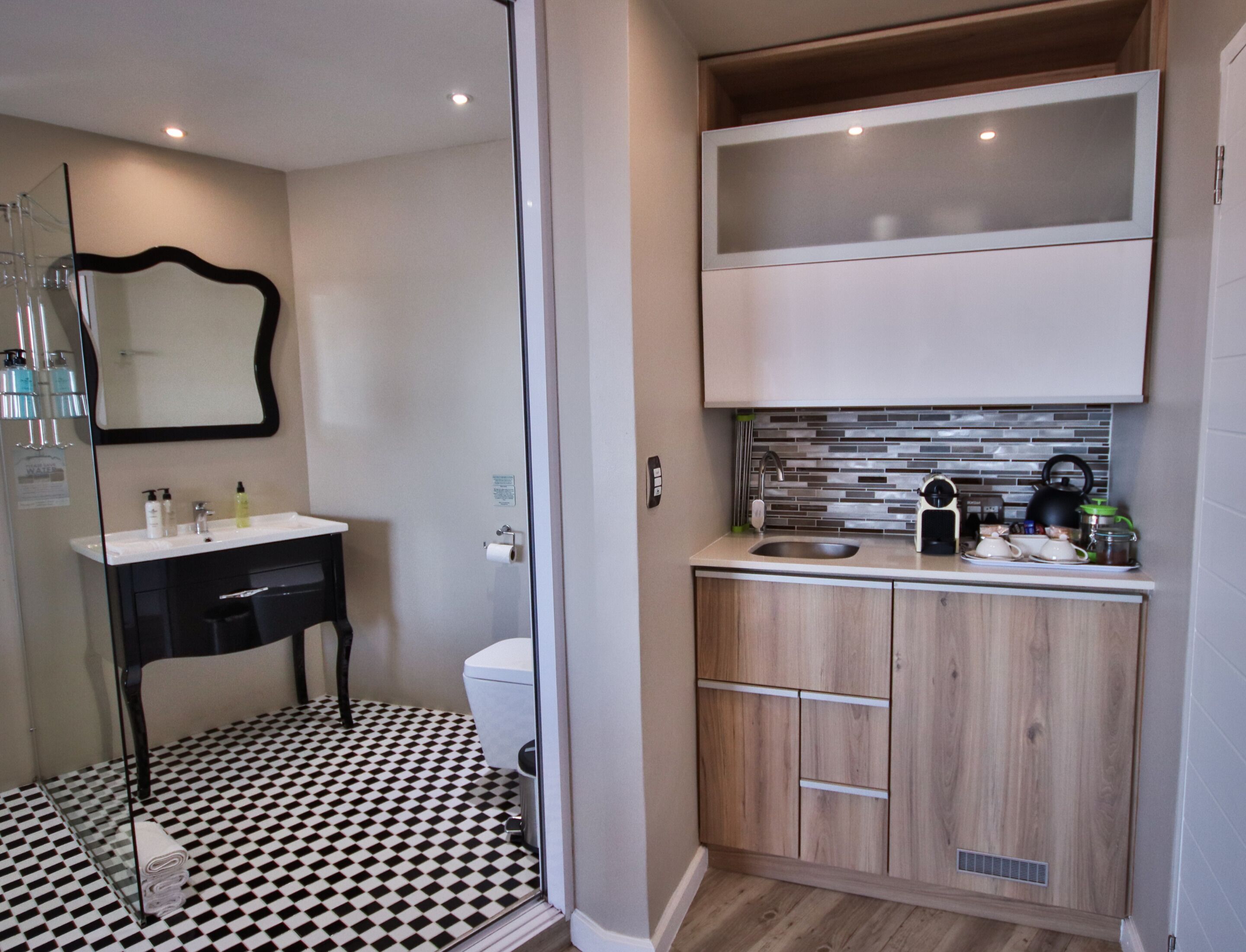 A compact bathroom with a black and white checkered floor, a modern sink, and a toilet.