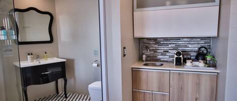 A compact bathroom with a black and white checkered floor, a modern sink, and a toilet.