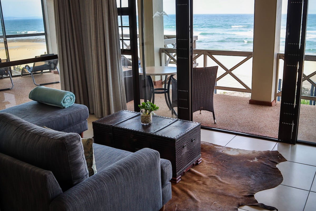 Un salon moderne avec vue sur la plage et l’océan.