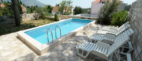 Una piscina al aire libre, camas de piscina gratis, sombrillas