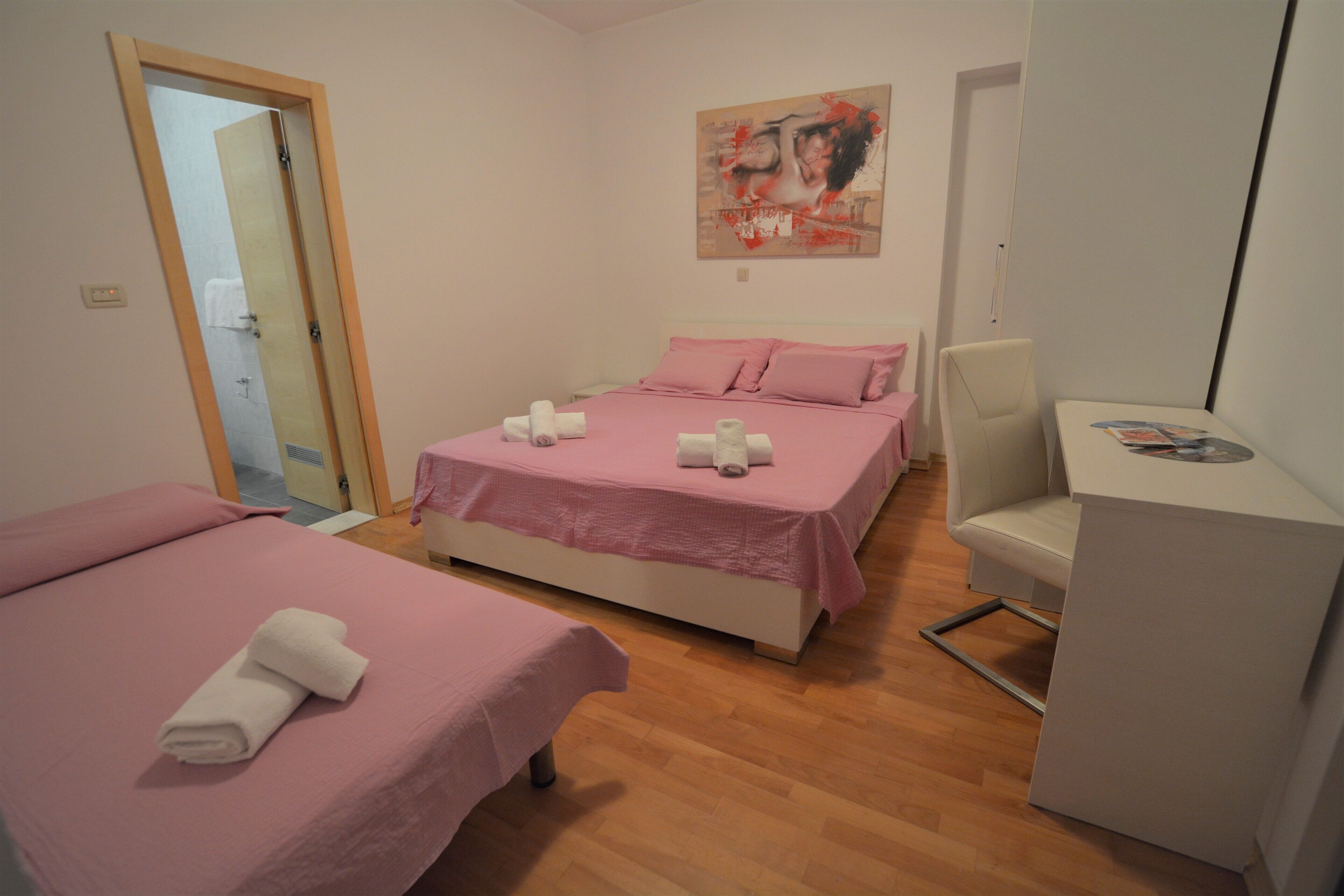 Ein Schlafzimmer mit zwei Betten, einem Schreibtisch und einem Stuhl.