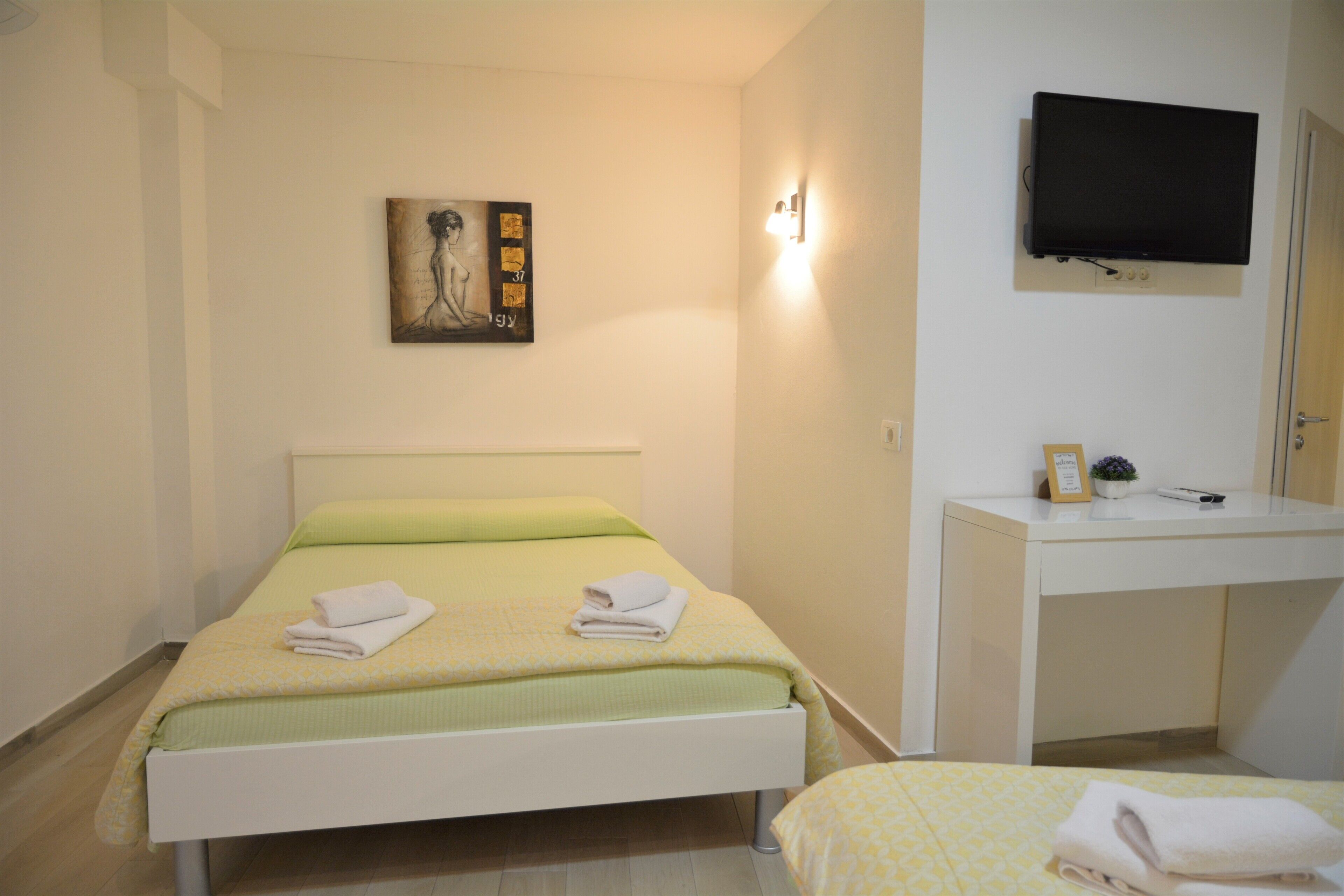 Una habitación de hotel con una cama, un escritorio y un televisor.