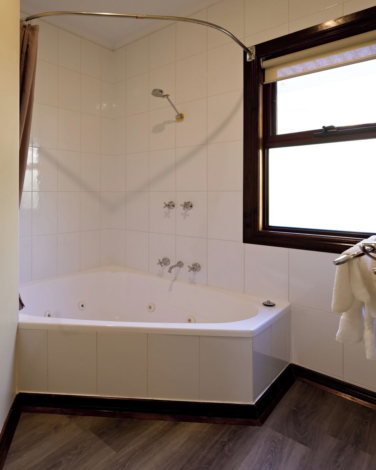 A modern bathroom with a freestanding bathtub, a shower enclosure, and a window providing natural light.