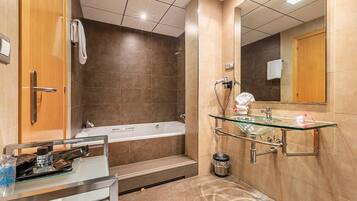 A modern bathroom with a glass-enclosed sink, a bathtub, and a shower area.