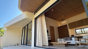 Un espacio exterior moderno con sofá, sillones y una mesita de centro.