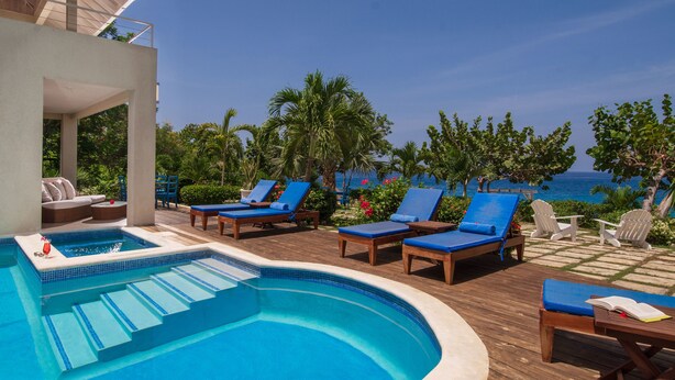 A pool area with lounge chairs and a view of the ocean. - Little Waters on the Cliff (Negril)