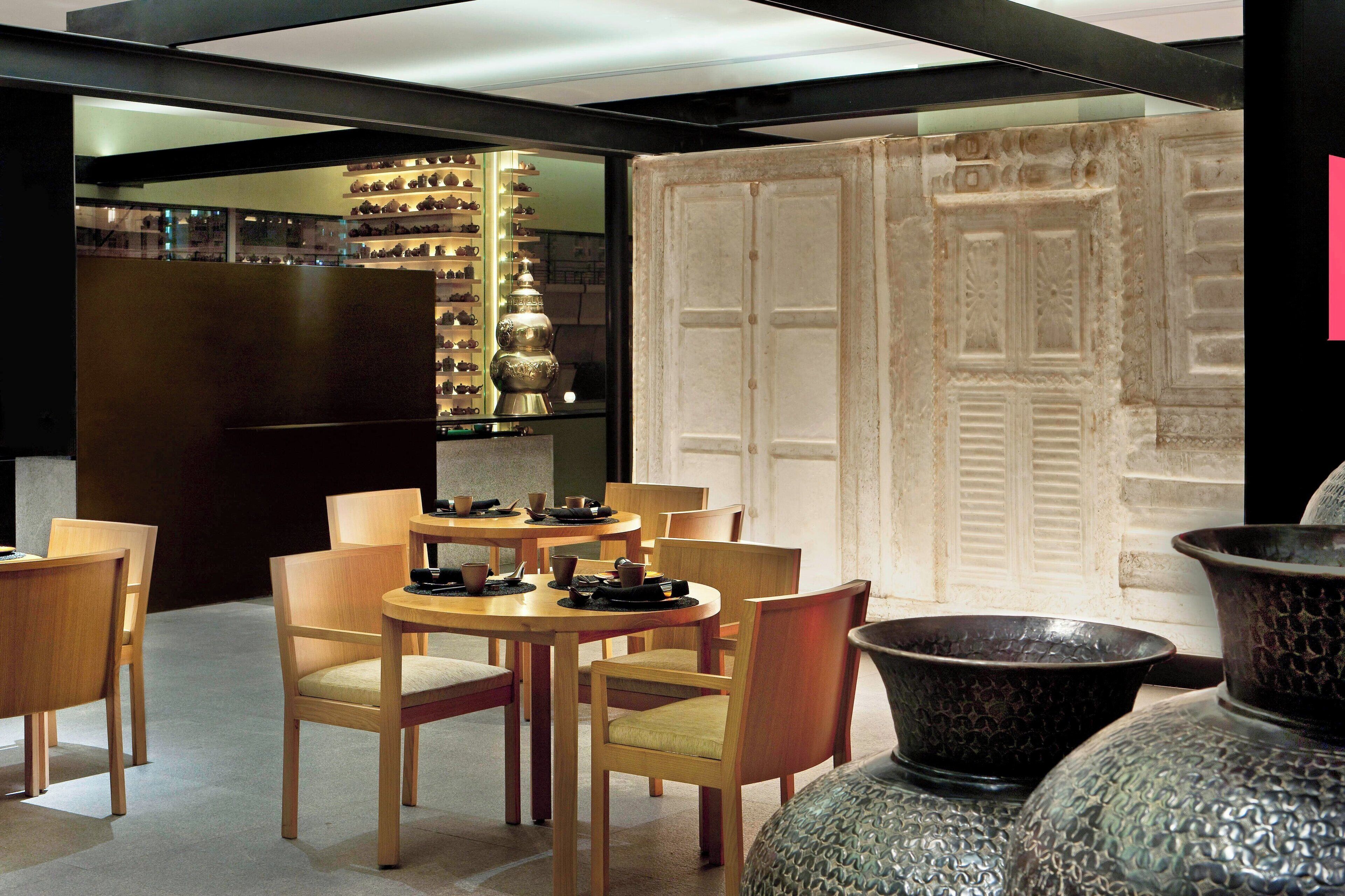 A dining area with wooden tables and chairs, a display of shoes, and a decorative door.