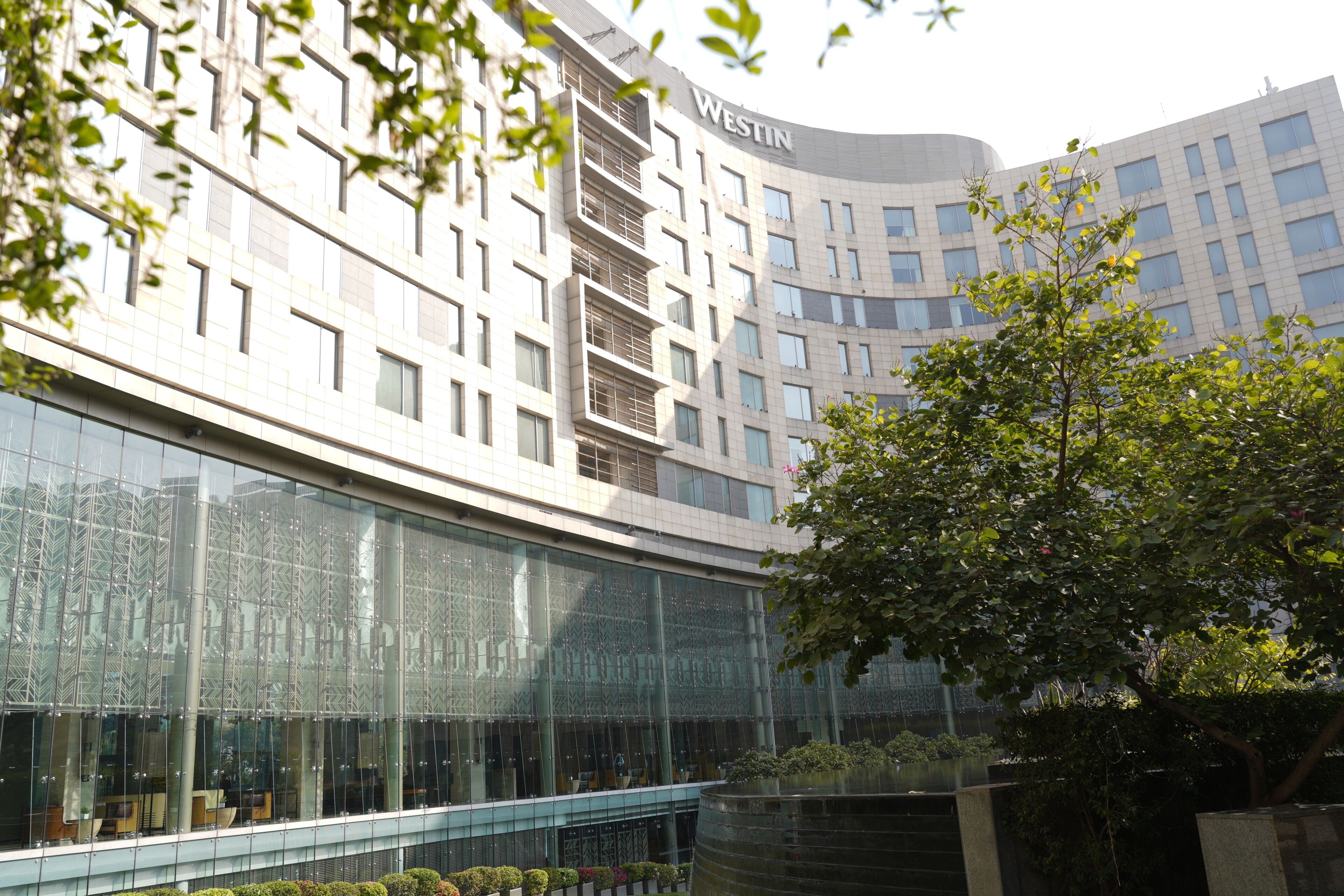 A modern building with a curved facade, large windows, and the name 'WESTIN' visible.