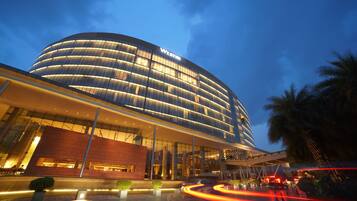 A modern hotel with a curved facade, large glass windows, and a prominent "WESTIN" sign.