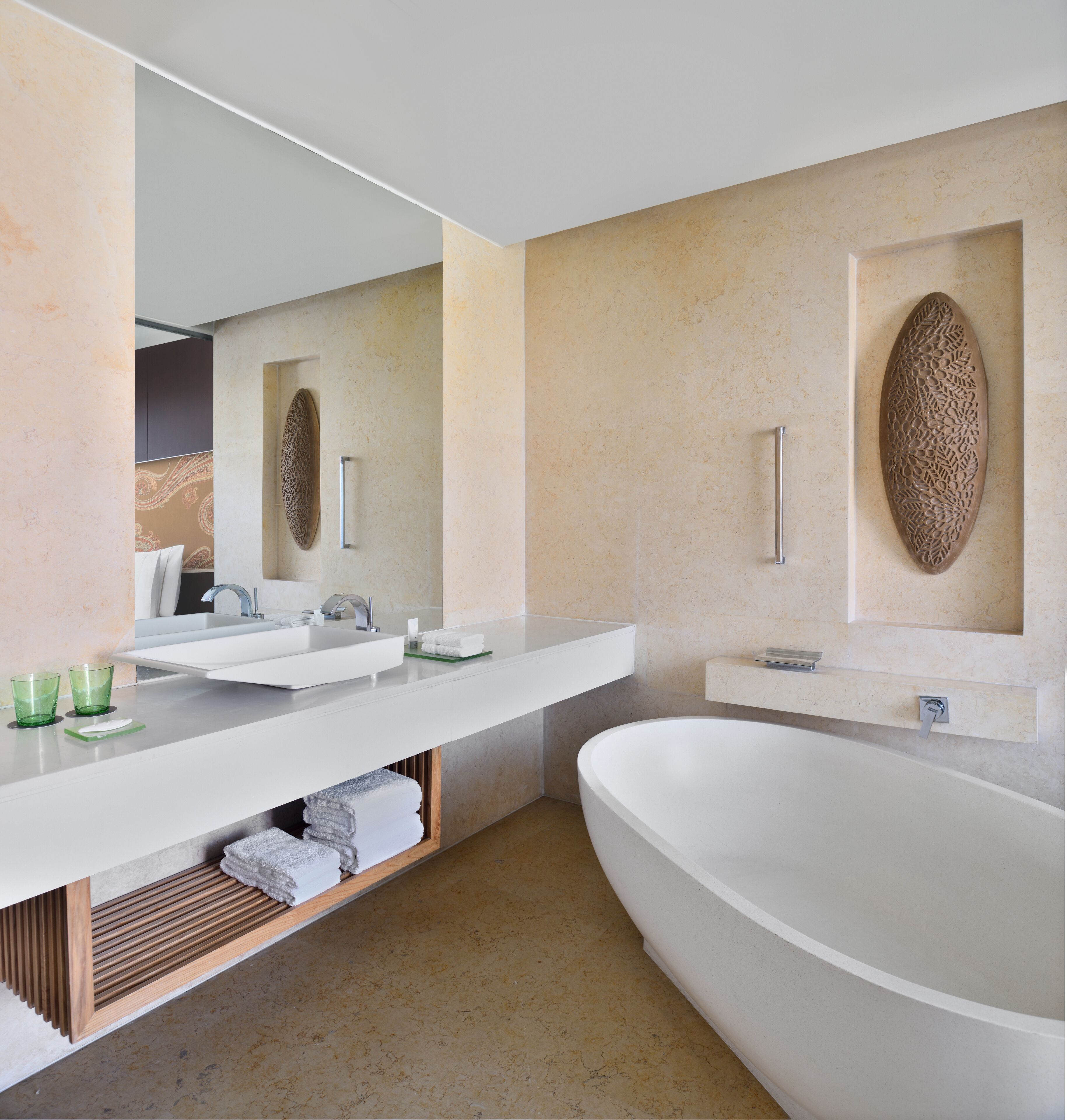 A modern bathroom with a large freestanding bathtub, a double sink vanity, and a mirror above the vanity.