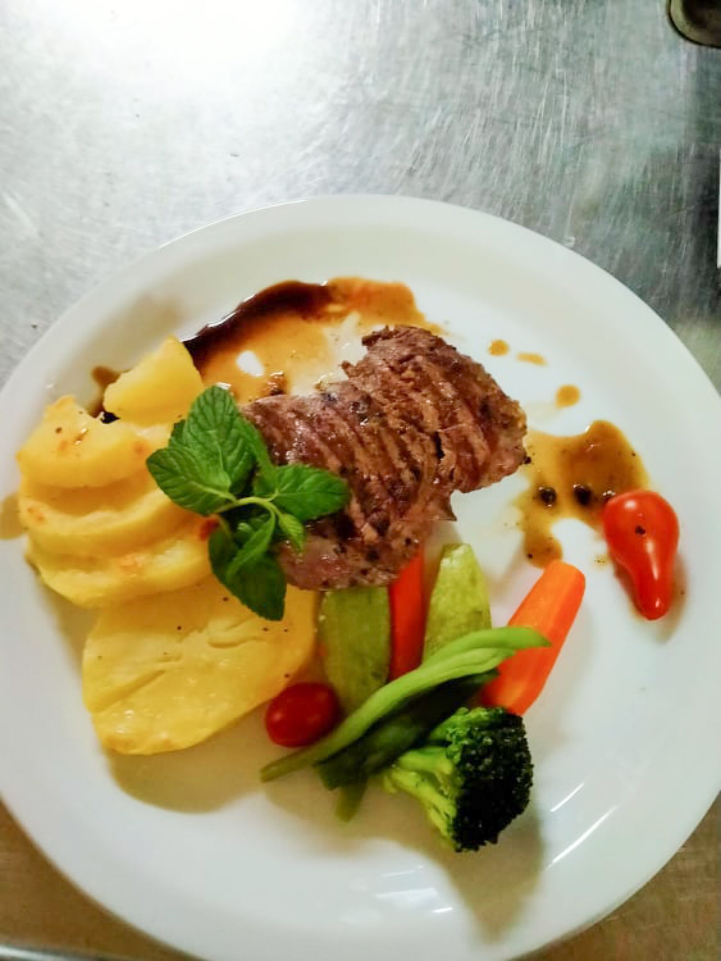 A plate with a steak, mashed potatoes, and vegetables.