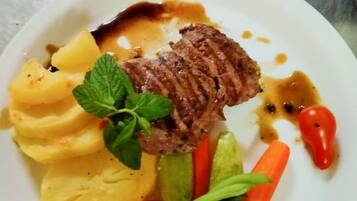 Um prato com bife, purê de batatas e legumes.
