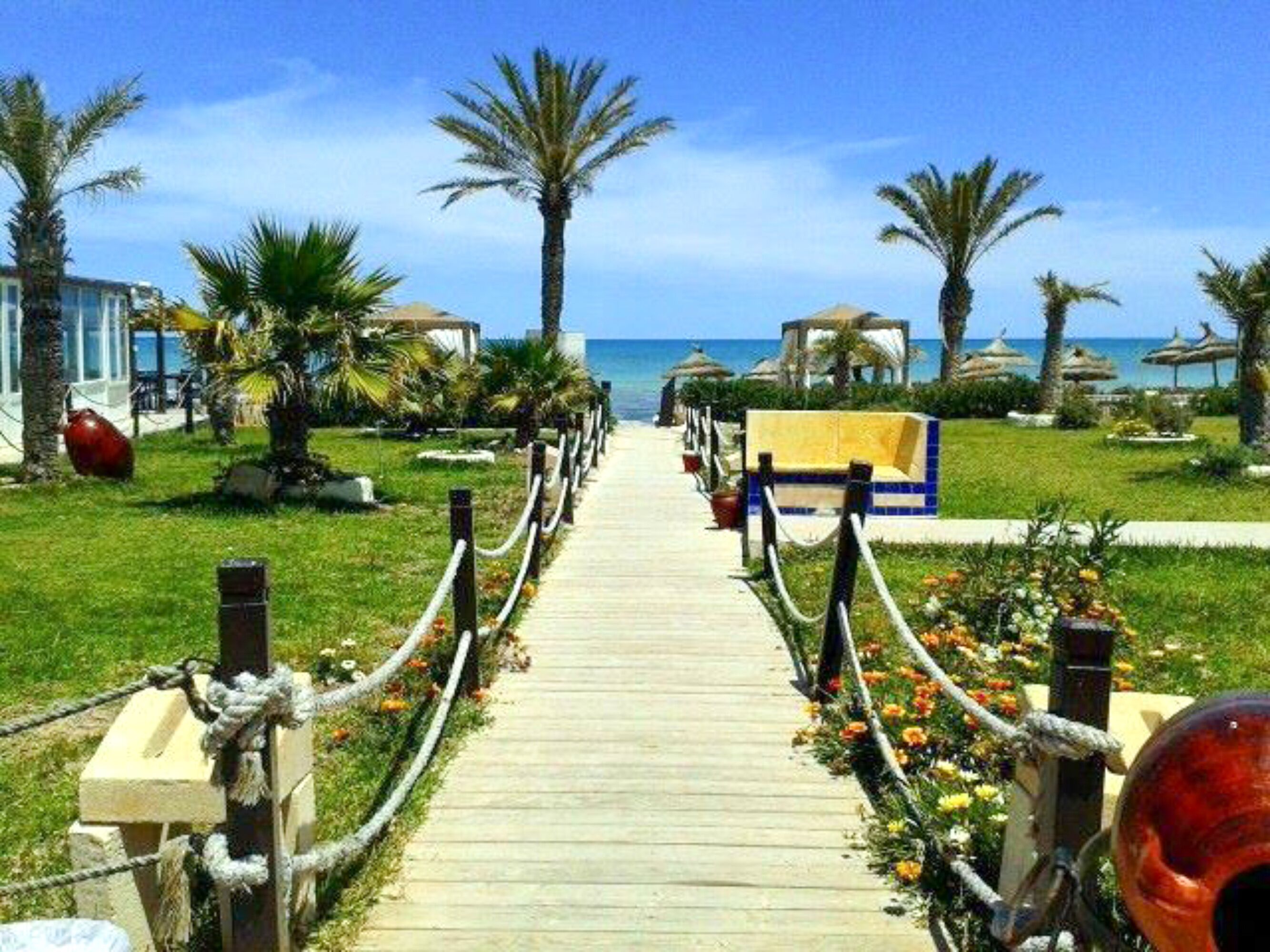 På stranden, solsenger, parasoller og strandhåndklær