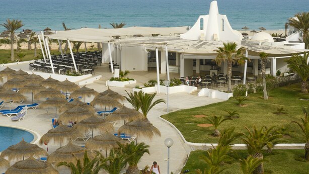 A resort with a pool, umbrellas, and a view of the ocean. - Vincci Helios Beach (Aghir)