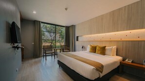 Ein modernes Hotelzimmer mit einem großen Bett, einem Schreibtisch, einem Stuhl und einem an der Wand befestigten Fernseher.