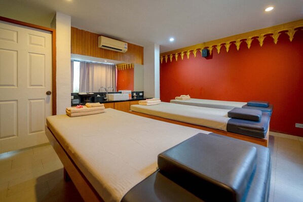 A room with two beds, a massage table, a sink, and a mirror. - Sukhothai Treasure Resort & Spa (Sukhothai)