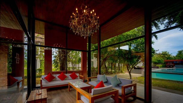 Un espacio interior moderno con muebles de madera, ventanas amplias y una lámpara de araña.