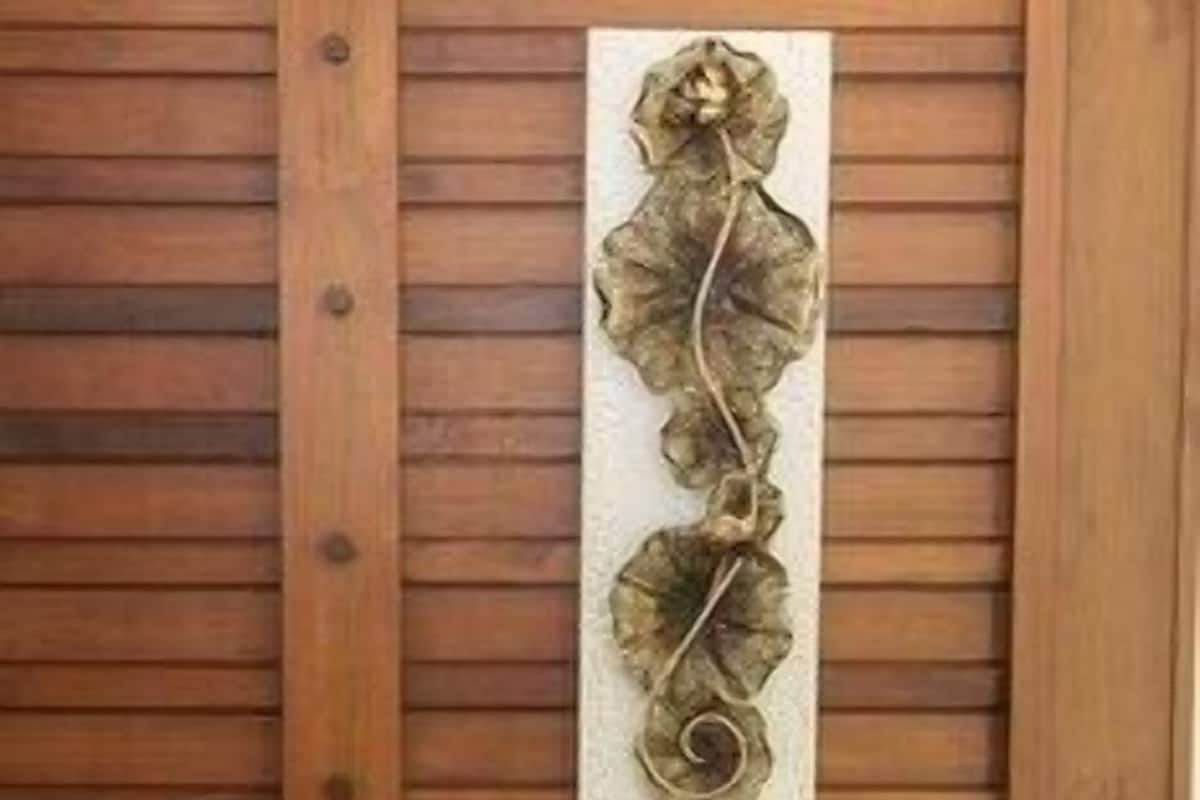 A wooden wall panel with a decorative leaf design.