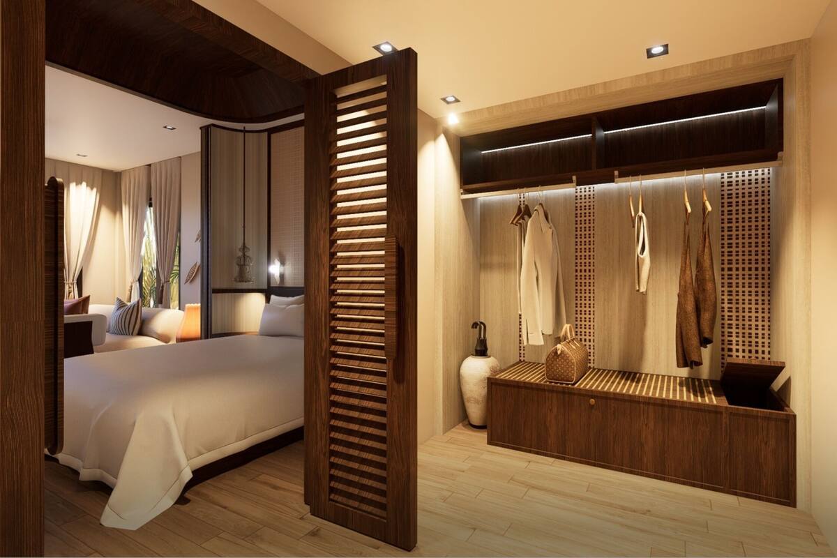 A modern bedroom with a large bed, a walk-in closet with hanging clothes, and a wooden floor.
