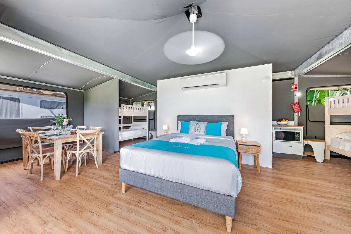 Une chambre moderne avec un lit, des tables de chevet, un bureau et des lits superposés.