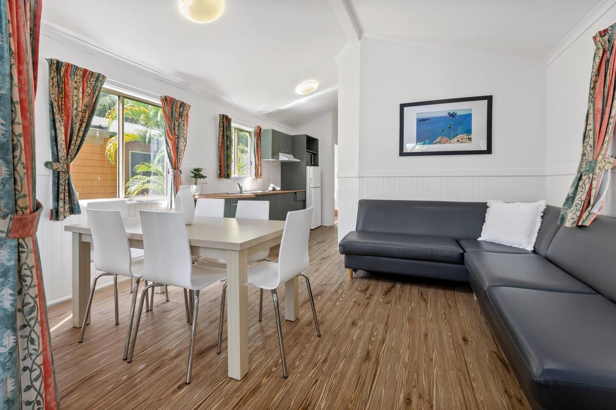 Un salon moderne avec un canapé, une table à manger et des chaises.