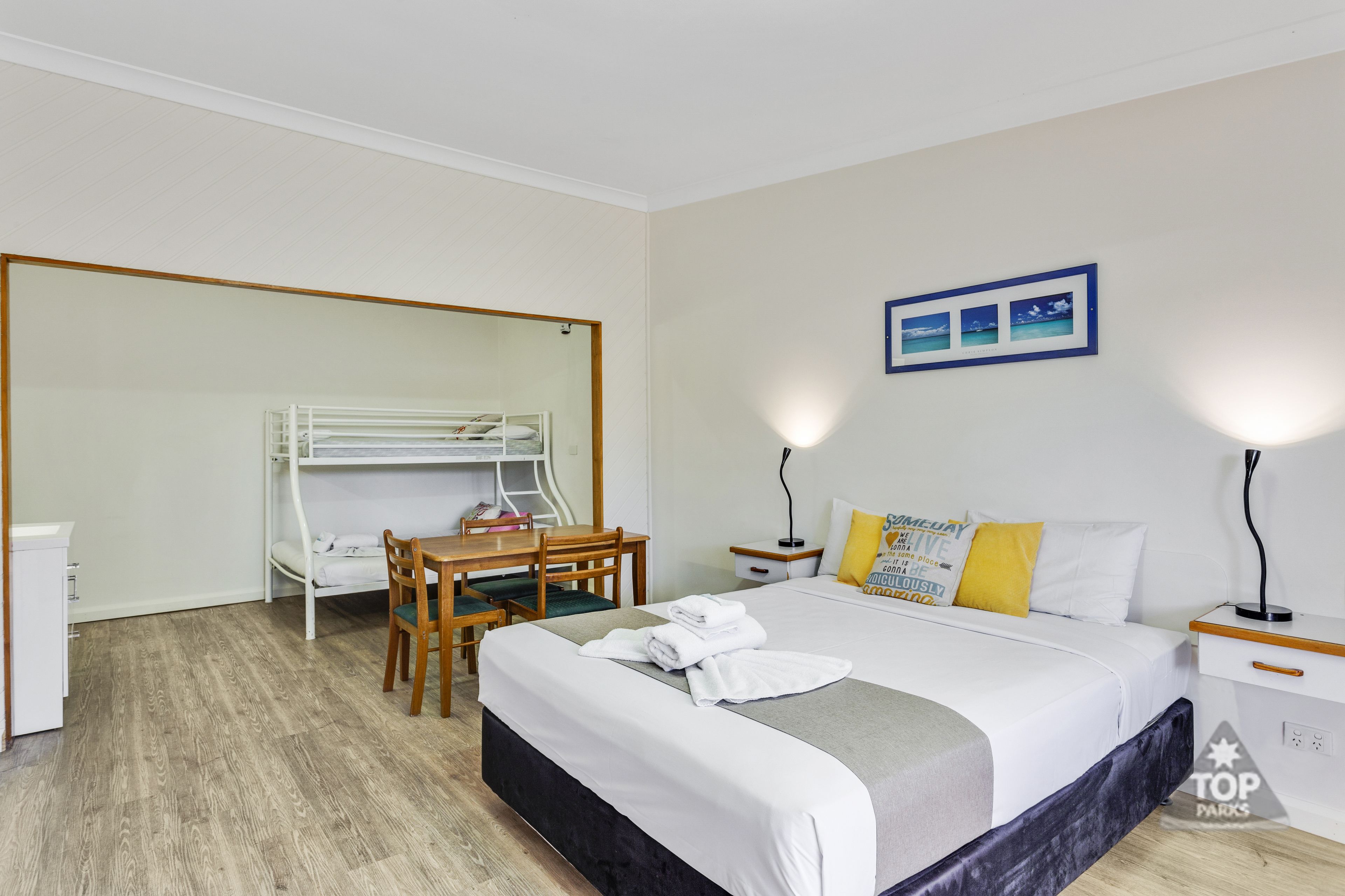 Een hotelkamer met een stapelbed, een bureau en een stoel.