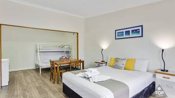 Een hotelkamer met een stapelbed, een bureau en een stoel.