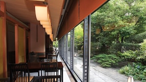 A restaurant with a view of a garden through large windows. - Kyoto Garden Palace (Kyoto)