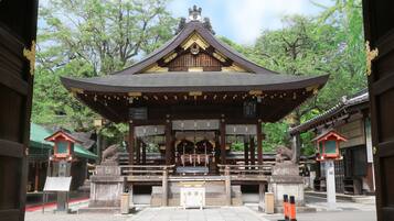 Un templo japonés tradicional con un santuario central, rodeado de faroles de piedra y un sendero de piedra.