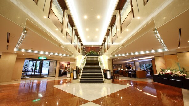 A spacious lobby with a central staircase, a reception desk, and a large window. - Kyoto Garden Palace (Kyoto)