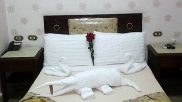 Una habitación de hotel con cama, mesita de noche y un cuadro enmarcado en la pared.